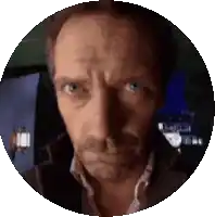 a close up of a man 's face in a circle with a blue background