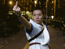 a man wearing a white shirt and a blue shirt giving the middle finger