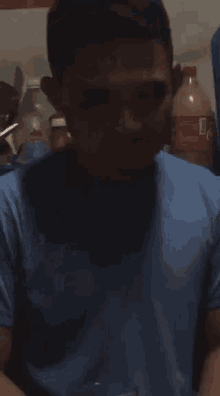 a man in a blue shirt has a coca cola bottle behind him