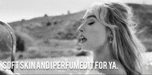 a black and white photo of a woman looking in a mirror with the words soft skin and perfumed it for ya