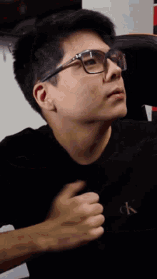 a man wearing glasses and a black shirt with the letter ck on it