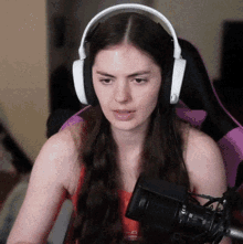 a woman wearing headphones is sitting in a chair with a microphone