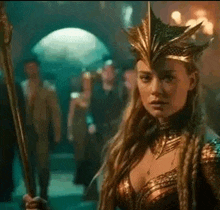 a woman is wearing a crown and holding a sword in a dark room .