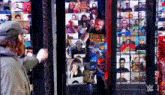 a man in a stunt world shirt stands in front of a wall of people