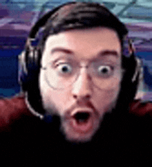 a close up of a man wearing headphones and glasses .