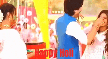 a couple of people standing next to each other with the words happy holi on the bottom .