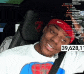 a man wearing a red nike headband is sitting in a car with the number 39,628,11 on the side