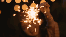 a woman is holding a sparkler in her hand