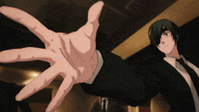 a man in a suit and tie reaches out with his hand