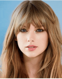 a close up of a woman 's face with long blonde hair and bangs