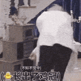 a man in a white shirt and black pants is standing in front of a table .