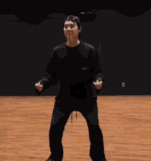 a man in a black hat is dancing on a wooden floor in a room .