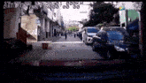 a car is driving down a busy street with a lot of cars parked on the side of the road .