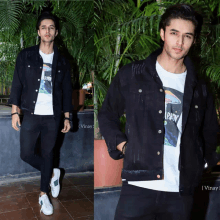 a man wearing a black jacket and a white t-shirt that says ' a party ' on it