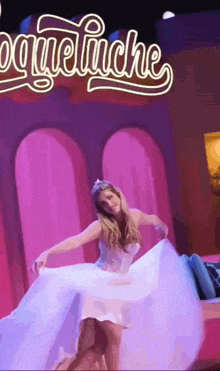 a woman in a white dress is dancing in front of a neon sign that says " paqueliche "