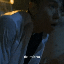 a close up of a person 's shoulder with the words de michu written on the bottom