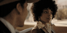 a man and a woman are sitting in a car and looking at each other