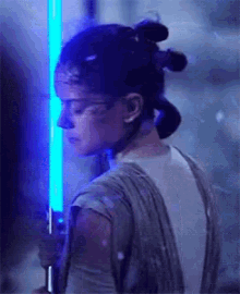 a woman is holding a blue light saber .