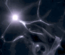 a person is standing in a dark room with a light coming out of the ceiling .