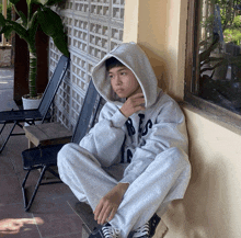 a person wearing a grey hoodie with the letter l on it