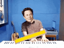 elon musk is playing a piano with a yellow ribbon between his fingers