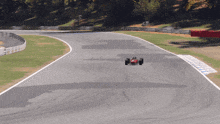 a red race car is driving on a track