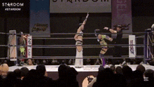 a woman is holding a sword in a wrestling ring .