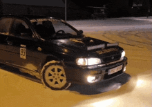 a black subaru with the number 99 on the side