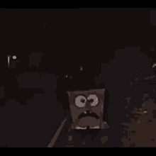 a spongebob squarepants character is standing in the dark with a surprised look on his face .