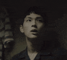 a man in a dark room looks down at something