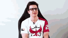 a man wearing glasses and a white shirt with the number 2 on the sleeve