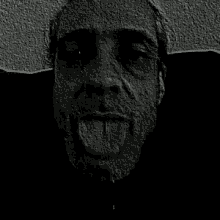a black and white photo of a man with his tongue out .