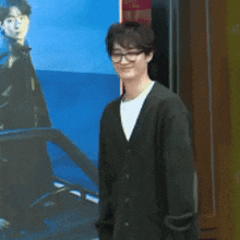 a young man wearing glasses and a black jacket