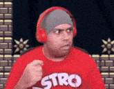 a man wearing headphones and a red shirt with stro on it