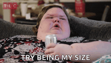 a woman is laying on a couch with a can of soda and the words try being my size above her