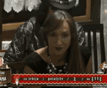 a woman is sitting at a table with a man in a cowboy hat