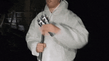 a man in a white jacket is holding a microphone in his hand