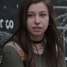 a girl stands in front of a sign that says " t to " on it
