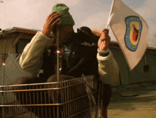 a man wearing a wolf jacket is holding a small flag