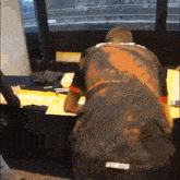 a man with a tattoo on his back is sitting at a desk .