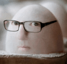 a close up of a person wearing glasses and looking at something