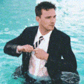 a man in a wet suit and tie is in the water