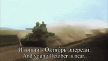 a tank is driving down a dirt road and the words and young october is near