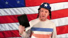 a man wearing a helmet and holding a bible stands in front of an american flag