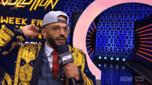 a man is holding a microphone with aew on it