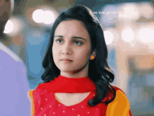 a girl wearing a red and yellow dress looks sad