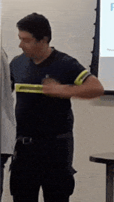 a man wearing a black shirt with a yellow stripe on the sleeve