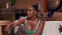 a woman in a blue dress is sitting on a couch with her hands on her hips