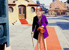 a man in a purple suit stands in front of a building with the word wonka on it