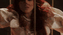 a woman with red hair is standing in a dark room